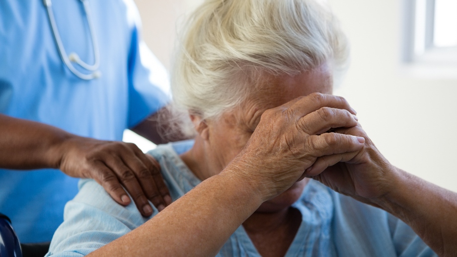 nurse-consoling-senior-woman-at-nursing-home-2021-08-28-16-45-54-utc